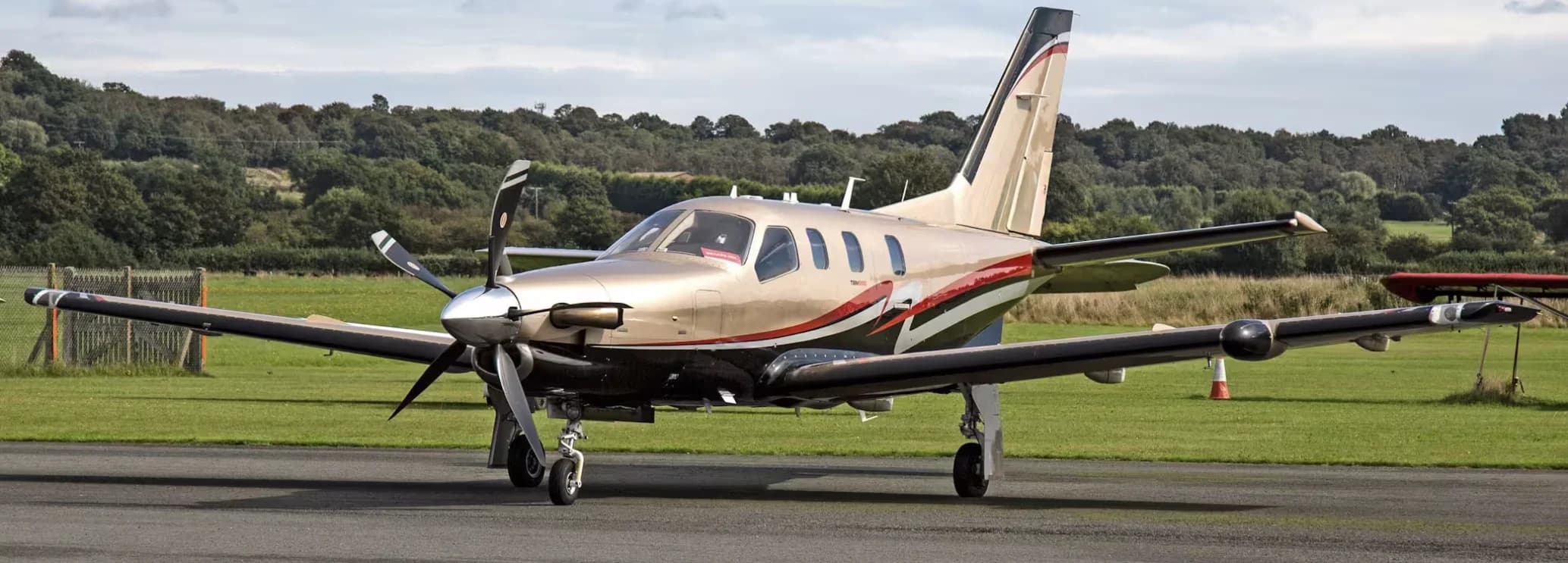 Daher TBM 850 single-engine turboprop parked on the tarmac, showcasing its sleek design and high-speed regional charter capabilities.