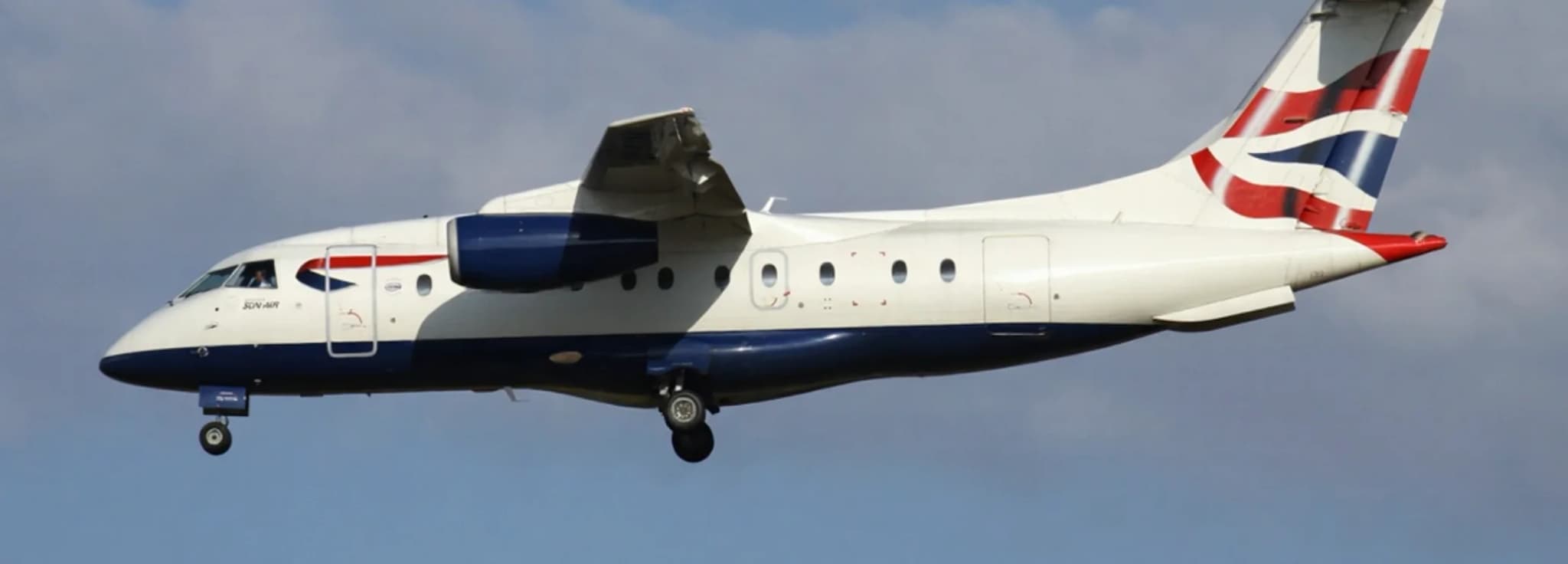 Private regional turbofan jet Dornier 328JET flying overhead during approach.