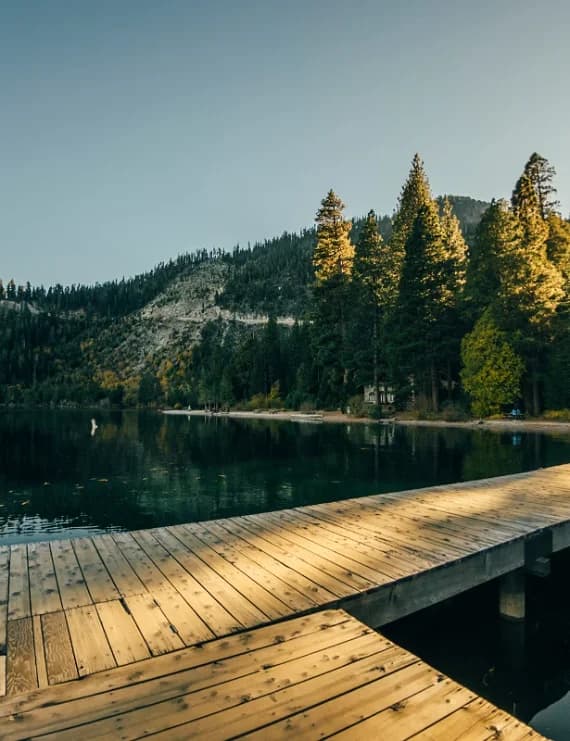 Sunbeam over a wooden pier on the clear waters of Lake Tahoe at sunset