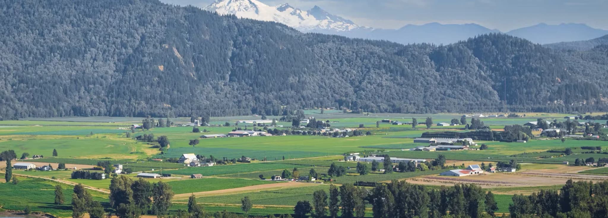 Aerial view of the Fraser Valley and mountains near Abbotsford, BC for private jet charter travelers