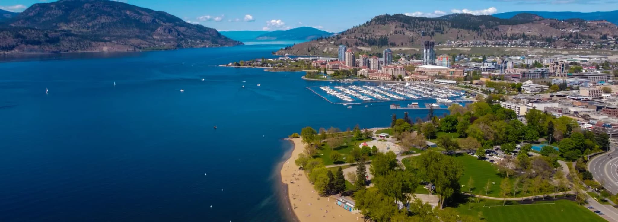 Aerial view of Okanagan Lake, waterfront parks, and downtown Kelowna for private jet travelers