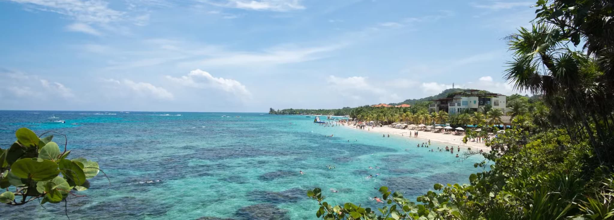 Aerial view of turquoise Caribbean waters and coral reefs along West Bay Beach in Roatán, Honduras.