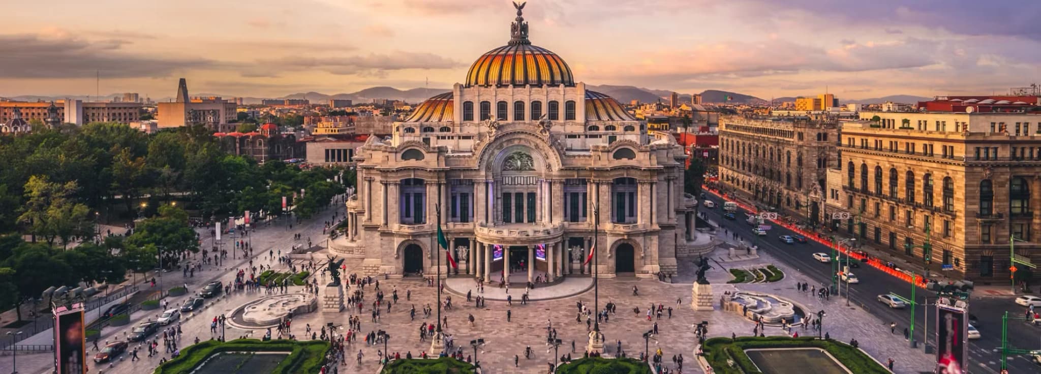 High-angle view of the Palacio de Bellas Artes palace and Alameda Central plaza at sunset in downtown Mexico City.