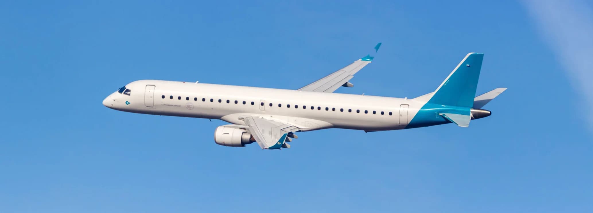 Embraer 195 regional jet in flight showing 92-foot cabin configured for 120-146 passenger group charter with 2+2 commercial seating
