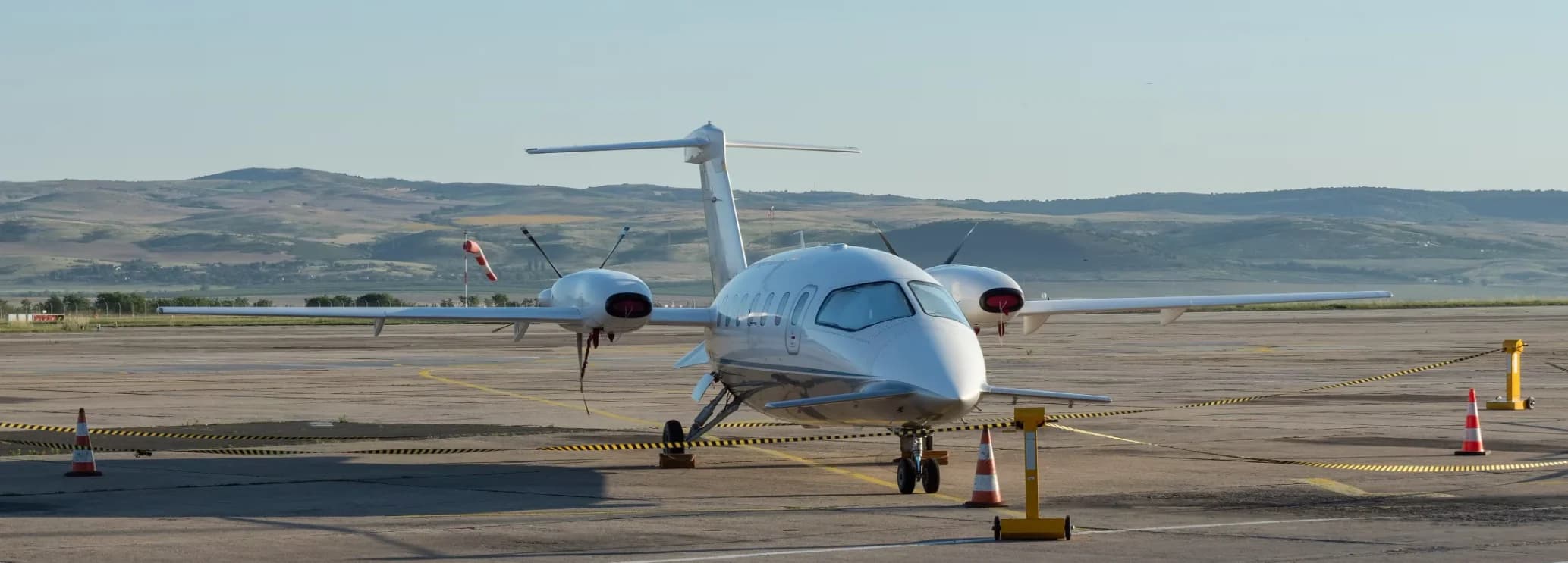 Original Piaggio Avanti (P.180) twin-engine turboprop parked on the apron, showcasing its distinctive pusher-propellers, forward canard wing, and unique three-surface design.