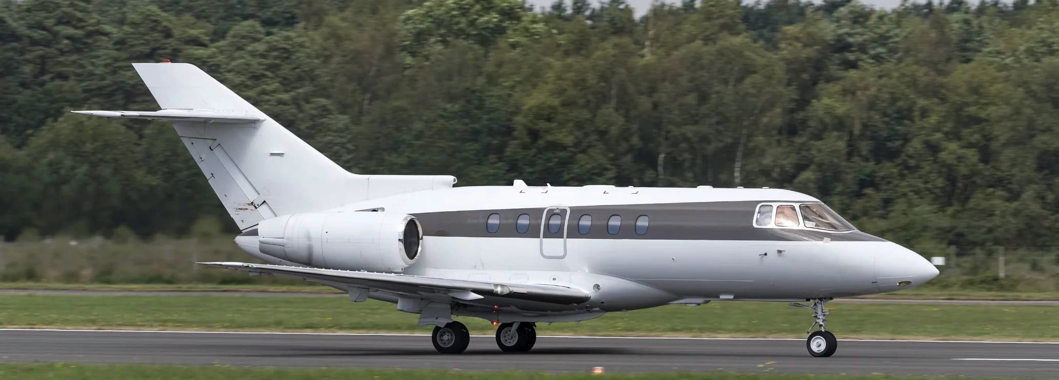 Hawker 750 midsize private jet chartered by Hogani Jets parked on the airfield tarmac.