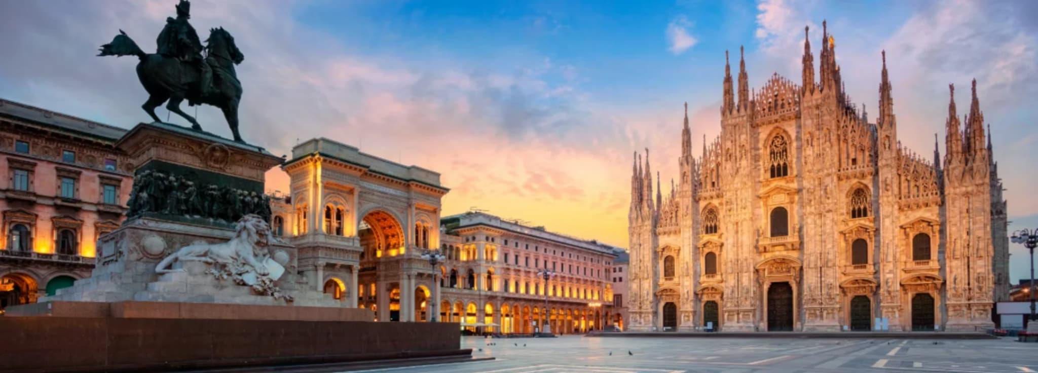 Aerial cityscape of Milan featuring the Duomo di Milano cathedral under clear skies.