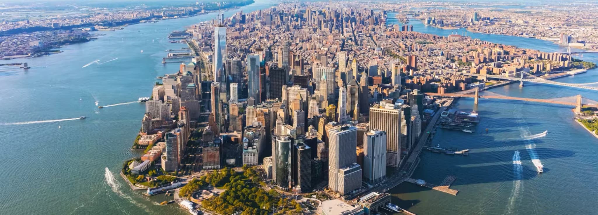 Aerial view of Lower Manhattan skyline, One World Trade Center, Battery Park, and surrounding rivers in New York City